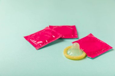 Renkli arka planda prezervatifler. Paketlemede renkli meyve temalı prezervatifler. Güvenli seks konsepti. Doğum kontrol hapı. Farklı doğum kontrol yöntemleri. AİDS önleme. Dünya AIDS Günü. Cinsel sağlık.