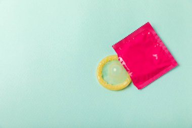 Renkli arka planda prezervatifler. Paketlemede renkli meyve temalı prezervatifler. Güvenli seks konsepti. Doğum kontrol hapı. Farklı doğum kontrol yöntemleri. AİDS önleme. Dünya AIDS Günü. Cinsel sağlık.