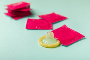 Renkli arka planda prezervatifler. Paketlemede renkli meyve temalı prezervatifler. Güvenli seks konsepti. Doğum kontrol hapı. Farklı doğum kontrol yöntemleri. AİDS önleme. Dünya AIDS Günü. Cinsel sağlık.