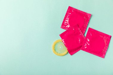 Renkli arka planda prezervatifler. Paketlemede renkli meyve temalı prezervatifler. Güvenli seks konsepti. Doğum kontrol hapı. Farklı doğum kontrol yöntemleri. AİDS önleme. Dünya AIDS Günü. Cinsel sağlık.