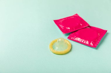 Renkli arka planda prezervatifler. Paketlemede renkli meyve temalı prezervatifler. Güvenli seks konsepti. Doğum kontrol hapı. Farklı doğum kontrol yöntemleri. AİDS önleme. Dünya AIDS Günü. Cinsel sağlık.