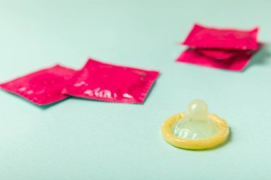 Renkli arka planda prezervatifler. Paketlemede renkli meyve temalı prezervatifler. Güvenli seks konsepti. Doğum kontrol hapı. Farklı doğum kontrol yöntemleri. AİDS önleme. Dünya AIDS Günü. Cinsel sağlık.