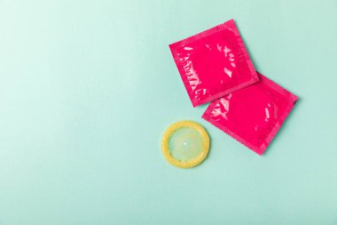 Renkli arka planda prezervatifler. Paketlemede renkli meyve temalı prezervatifler. Güvenli seks konsepti. Doğum kontrol hapı. Farklı doğum kontrol yöntemleri. AİDS önleme. Dünya AIDS Günü. Cinsel sağlık.