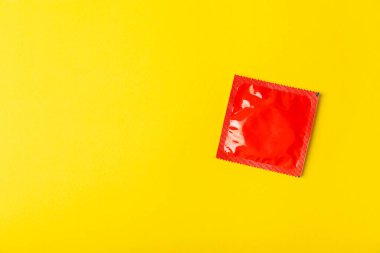 Renkli arka planda prezervatifler. Paketlemede renkli meyve temalı prezervatifler. Güvenli seks konsepti. Doğum kontrol hapı. Farklı doğum kontrol yöntemleri. AİDS önleme. Dünya AIDS Günü. Cinsel sağlık.