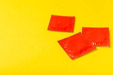 Renkli arka planda prezervatifler. Paketlemede renkli meyve temalı prezervatifler. Güvenli seks konsepti. Doğum kontrol hapı. Farklı doğum kontrol yöntemleri. AİDS önleme. Dünya AIDS Günü. Cinsel sağlık.