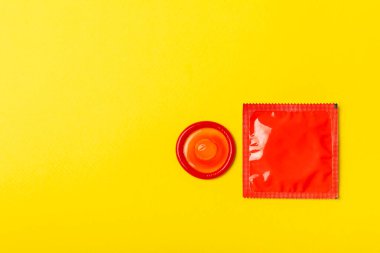 Renkli arka planda prezervatifler. Paketlemede renkli meyve temalı prezervatifler. Güvenli seks konsepti. Doğum kontrol hapı. Farklı doğum kontrol yöntemleri. AİDS önleme. Dünya AIDS Günü. Cinsel sağlık.