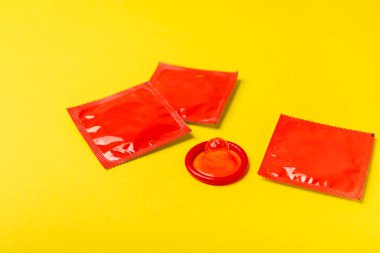 Renkli arka planda prezervatifler. Paketlemede renkli meyve temalı prezervatifler. Güvenli seks konsepti. Doğum kontrol hapı. Farklı doğum kontrol yöntemleri. AİDS önleme. Dünya AIDS Günü. Cinsel sağlık.