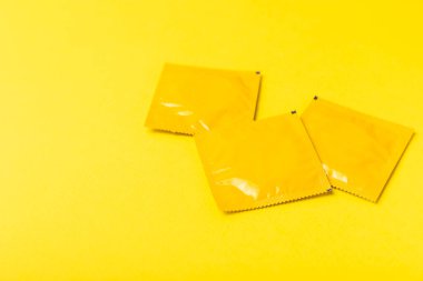 Renkli arka planda prezervatifler. Paketlemede renkli meyve temalı prezervatifler. Güvenli seks konsepti. Doğum kontrol hapı. Farklı doğum kontrol yöntemleri. AİDS önleme. Dünya AIDS Günü. Cinsel sağlık.