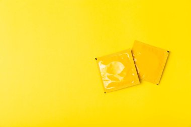 Renkli arka planda prezervatifler. Paketlemede renkli meyve temalı prezervatifler. Güvenli seks konsepti. Doğum kontrol hapı. Farklı doğum kontrol yöntemleri. AİDS önleme. Dünya AIDS Günü. Cinsel sağlık.