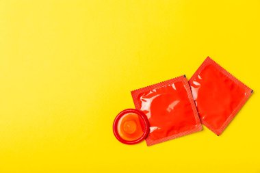 Renkli arka planda prezervatifler. Paketlemede renkli meyve temalı prezervatifler. Güvenli seks konsepti. Doğum kontrol hapı. Farklı doğum kontrol yöntemleri. AİDS önleme. Dünya AIDS Günü. Cinsel sağlık.