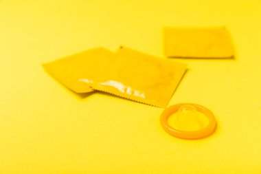 Renkli arka planda prezervatifler. Paketlemede renkli meyve temalı prezervatifler. Güvenli seks konsepti. Doğum kontrol hapı. Farklı doğum kontrol yöntemleri. AİDS önleme. Dünya AIDS Günü. Cinsel sağlık.