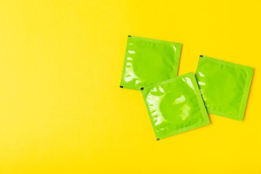 Renkli arka planda prezervatifler. Paketlemede renkli meyve temalı prezervatifler. Güvenli seks konsepti. Doğum kontrol hapı. Farklı doğum kontrol yöntemleri. AİDS önleme. Dünya AIDS Günü. Cinsel sağlık.