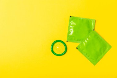 Renkli arka planda prezervatifler. Paketlemede renkli meyve temalı prezervatifler. Güvenli seks konsepti. Doğum kontrol hapı. Farklı doğum kontrol yöntemleri. AİDS önleme. Dünya AIDS Günü. Cinsel sağlık.