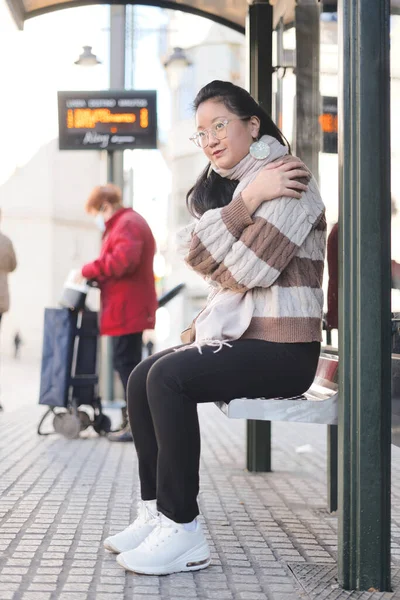 Gözlüklü Genç Asyalı Kız Otobüsü Beklerken Soğukta Oturuyor Ulaşım Kavramı — Stok fotoğraf