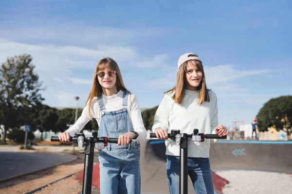Elektrikli Scooterlı Sarışın Kız Kardeşler Pompa Pistinde Güneşli Bir Öğleden — Stok fotoğraf