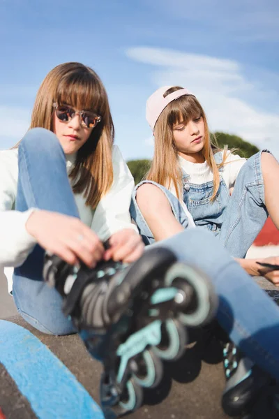 Primer Plano Dos Hermanas Rubias Adolescentes Sentadas Ajustando Sus Patines — Foto de Stock