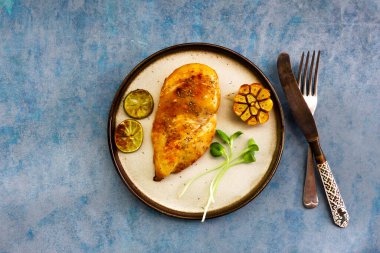 Tavuklu ızgara sarımsak ve limonlu mavi ahşap arka plan manzaralı, sağlıklı yemek kavramı..  