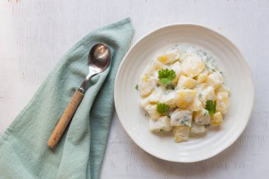 Potato salad creamy mayonnaise on wood background top view, copy space, healthy food concept.