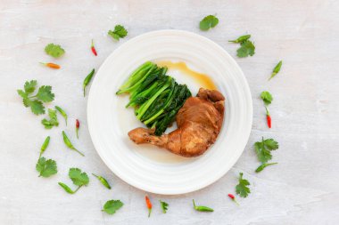 Chicken braised has kale garlic chili sauce in plate on white wood background top view, healthy food concept.