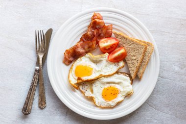 Fried egg bacon bread and coffee on wood background top view, breakfast food and drink concept.
