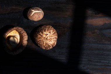 Koyu ahşap masa manzaralı kuru Shiitake mantarı, yakın çekim, sağlıklı gıda konsepti..