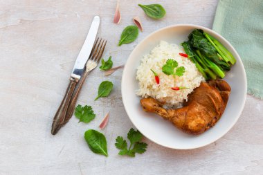 Chicken braised has rice kale garlic chili sauce in plate on white wood background top view, healthy food concept.