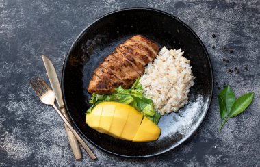 Izgara tavukta pirinç mangosu var. Arka planda, üst tarafta, sağlıklı yiyecek konseptinde..