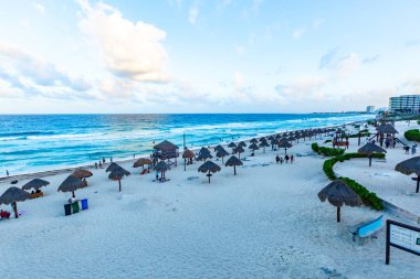 Gün doğumundan sonra Playa Delfines 'de çekilmiş canlı bir plaj fotoğrafı koleksiyonu. Meksika' nın Cancun kentindeki en ikonik halk plajlarından biri. Resimlerde yumuşak beyaz kum, turkuaz Karayip suları, palapalar (sazlı şemsiyeler) ve tropikal bitkiler yer alıyor.