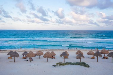 Gün doğumundan sonra Playa Delfines 'de çekilmiş canlı bir plaj fotoğrafı koleksiyonu. Meksika' nın Cancun kentindeki en ikonik halk plajlarından biri. Resimlerde yumuşak beyaz kum, turkuaz Karayip suları, palapalar (sazlı şemsiyeler) ve tropikal bitkiler yer alıyor.