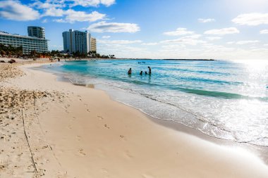 Cancun Otel Bölgesi 'ndeki Playa Chacmool' un güzel manzarası yumuşak beyaz kum, turkuaz Karayip suları ve kırsal bir cankurtaran kulesi gösteriyor. Fotoğraf, yakınlardaki yerlerden daha az kalabalık olan bu halk plajının huzurlu atmosferini yakalıyor. Uzun oteller!