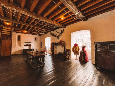 Şömineli büyük bir oda ve kırmızı elbise giymiş bir manken. Oda boş ve çok eski ve kırsal bir havası var. Kilkenny, İrlanda, Rothe House ve Garden