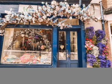 Kilkenny Ireland, Temmuz 2023 Mavi mağaza önü mavi bir kapı ve üzerinde kalp olan bir pencere. Mağaza vitrini çiçeklerle süslenmiş ve İrlanda, Kilkenny 'de mavi bir tentesi var.