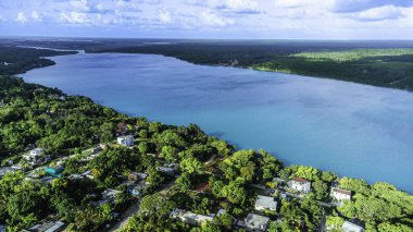 Bacalar, Mexico, Quintana Roo, Blue lake with a town on the shore. The water is calm and the sky is clear