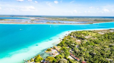 Bacalar, Mexico, Quintana Roo, Beautiful blue ocean with a green forest in the background. The water is calm and the sky is clear