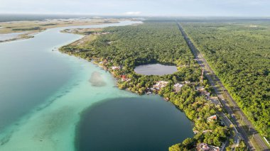 Bacalar, Mexico, Quintana Roo, Beautiful lake with a green forest in the background. The lake is surrounded by a small town
