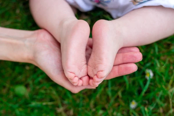 Pequenas Crianças Pés Nas Mães Mão Fundo Grama Suculenta Verde — Fotografia de Stock