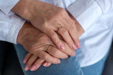 The hands of an elderly couple are held together and have wedding rings as a sign of unity and a happy marriage. Orthodox wedding rings. A symbol of love and strong relationships
