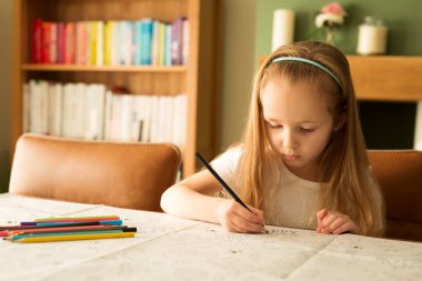Easter and the child. Development, drawing. Cute cute girl with blond hair paints an Easter picture in a bright interior