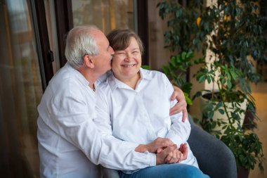 Emekli, mutlu bir evlilik, aşk. Yaşlı, kır saçlı bir adam, gülen karısına sarılıp onu öpüyor. Aynı kıyafet - beyaz gömlekler