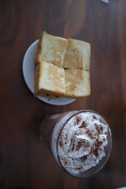 Toast with chocolate ice cream on a table isolated on a wooden background.