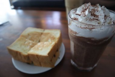 Toast with chocolate ice cream on a table isolated on a wooden background.