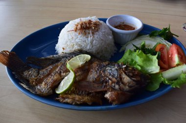 Delicious fried tilapia with white rice served on the table