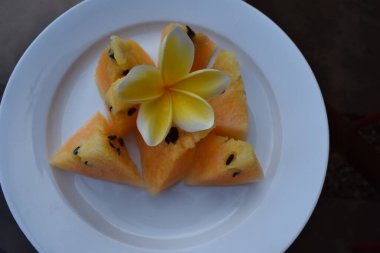 yellow watermelon pieces on a white plate