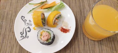 sushi and orange juice on a wooden table