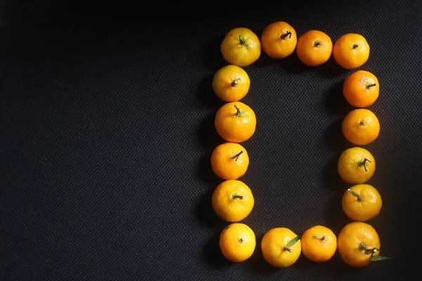 Numbers in arrangement Fresh Sicilian Mandarin oranges on black background.