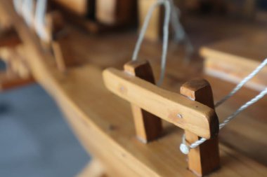 Masa başındaki ahşap bir yelkenlinin minyatür parçası.