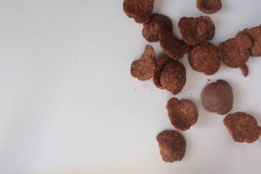 Beyaz arka planda izole edilmiş beyaz bir kasede kahverengi mısır gevreği. Boşluğu Kopyala