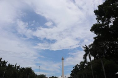 Monas Anıtı ağaçların arkasında.