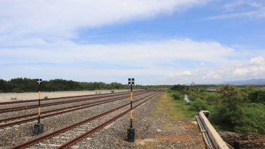 Mavi gökyüzü arkaplanına doğru uzanan çok kanallı rayların yakın görüntüsü