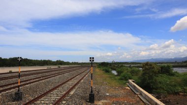 Mavi gökyüzü arkaplanına doğru uzanan çok kanallı rayların yakın görüntüsü